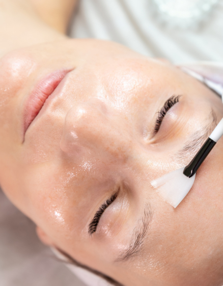 Close-up beautician doctor hand making anti-age procedure apply peeling acid young attractive female client at beauty clinic. Cosmetologist specialist doing skincare treatment. Health care therapy.